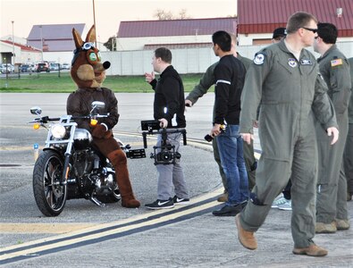 The Spurs Coyote pauses for instructions on the Joint Base San Antonio-Randolph, Texas flight line February 25 where Regular Air Force, Air Force Reserve, and civilian Airmen from the 340th Flying Training Group headquarters, 39th Flying Training Squadron T-6 Texan Flight, 12th Flying Training Wing Safety, 559th Flying Training Squadron T-6 team, and 3rd Combat Camera Squadron (JBSA-Lackland) members, and the NBA San Antonio Spurs production crew worked to put the Coyote through the pilot training process. Video footage will be used for a Spurs Military Appreciation video to be shown during the March 10 game. (U.S. Air Force photo by Janis El Shabazz)