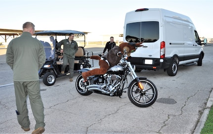 The Spurs Coyote climbs on his custom Harley on the Joint Base San Antonio-Randolph, Texas flight line February 25 where Regular Air Force, Air Force Reserve, and civilian Airmen from the 340th Flying Training Group headquarters, 39th Flying Training Squadron T-6 Texan Flight, 12th Flying Training Wing Safety, 559th Flying Training Squadron T-6 team, and 3rd Combat Camera Squadron (JBSA-Lackland) members, and the NBA San Antonio Spurs production crew worked to put the Coyote through the pilot training process. Video footage will be used for a Spurs Military Appreciation video to be shown during the March 10 game. (U.S. Air Force photo by Janis El Shabazz)