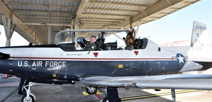 The Spurs Coyote gets last minute instructions for his simulated flight  from his friend 340th Flying Training Group’s – Lt. Col. Mark Pasierb – at Joint Base San Antonio-Randolph, Texas February 25 where Regular Air Force, Air Force Reserve, and civilian Airmen from the 340th Flying Training Group headquarters, 39th Flying Training Squadron T-6 Texan Flight, 12th Flying Training Wing Safety, 559th Flying Training Squadron T-6 team, and 3rd Combat Camera Squadron (JBSA-Lackland) members, and the NBA San Antonio Spurs production crew worked to put the Coyote through the pilot training process. Video footage will be used for a Spurs Military Appreciation video to be shown during the March 10 game.  (U.S. Air Force photo by Janis El Shabazz)