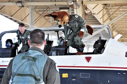 The Spurs Coyote and 340th Flying Training Group instructor pilot– Lt. Col. Mark Pasierb – exit the aircraft after the Coyote’s simulated flight at Joint Base San Antonio-Randolph, Texas February 25 where Regular Air Force, Air Force Reserve, and civilian Airmen from the 340th Flying Training Group headquarters, 39th Flying Training Squadron T-6 Texan Flight, 12th Flying Training Wing Safety, 559th Flying Training Squadron T-6 team, and 3rd Combat Camera Squadron (JBSA-Lackland) members, and the NBA San Antonio Spurs production crew worked to put the Coyote through the pilot training process. Video footage will be used for a Spurs Military Appreciation video to be shown during the March 10 game. (U.S. Air Force photo by Janis El Shabazz)