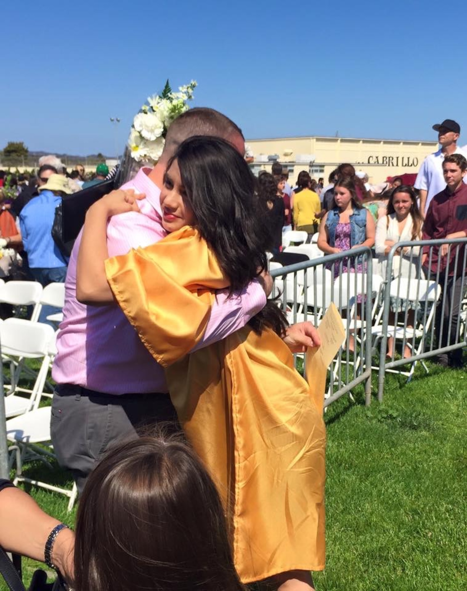 Dakotah Daniels, 17, hugs her father, Chief Master Sgt. Thomas Daniels, during her high school graduation ceremony at Cabrillo High School, Calif., in June 2015. (Courtesy photo)