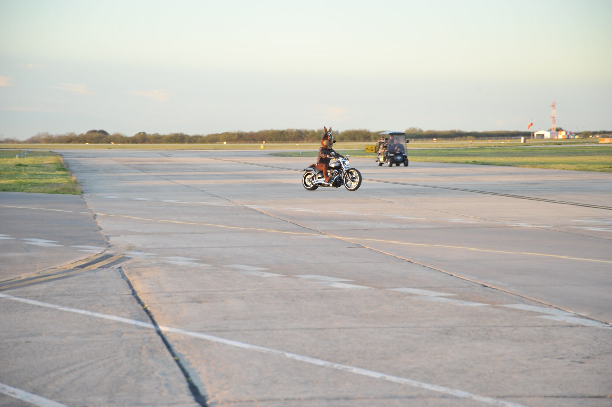 The Spurs Coyote drives around the Joint Base San Antonio-Randolph, Texas flight line February 25 where Regular Air Force, Air Force Reserve, and civilian Airmen from the 340th Flying Training Group headquarters, 39th Flying Training Squadron T-6 Texan Flight, 12th Flying Training Wing Safety, 559th Flying Training Squadron T-6 team, and 3rd Combat Camera Squadron (JBSA-Lackland) members, and the NBA San Antonio Spurs production crew worked to put the Coyote through the pilot training process. Video footage will be used for a Spurs Military Appreciation video to be shown during the March 10 game. (U.S. Air Force photo by Debbie Gildea)