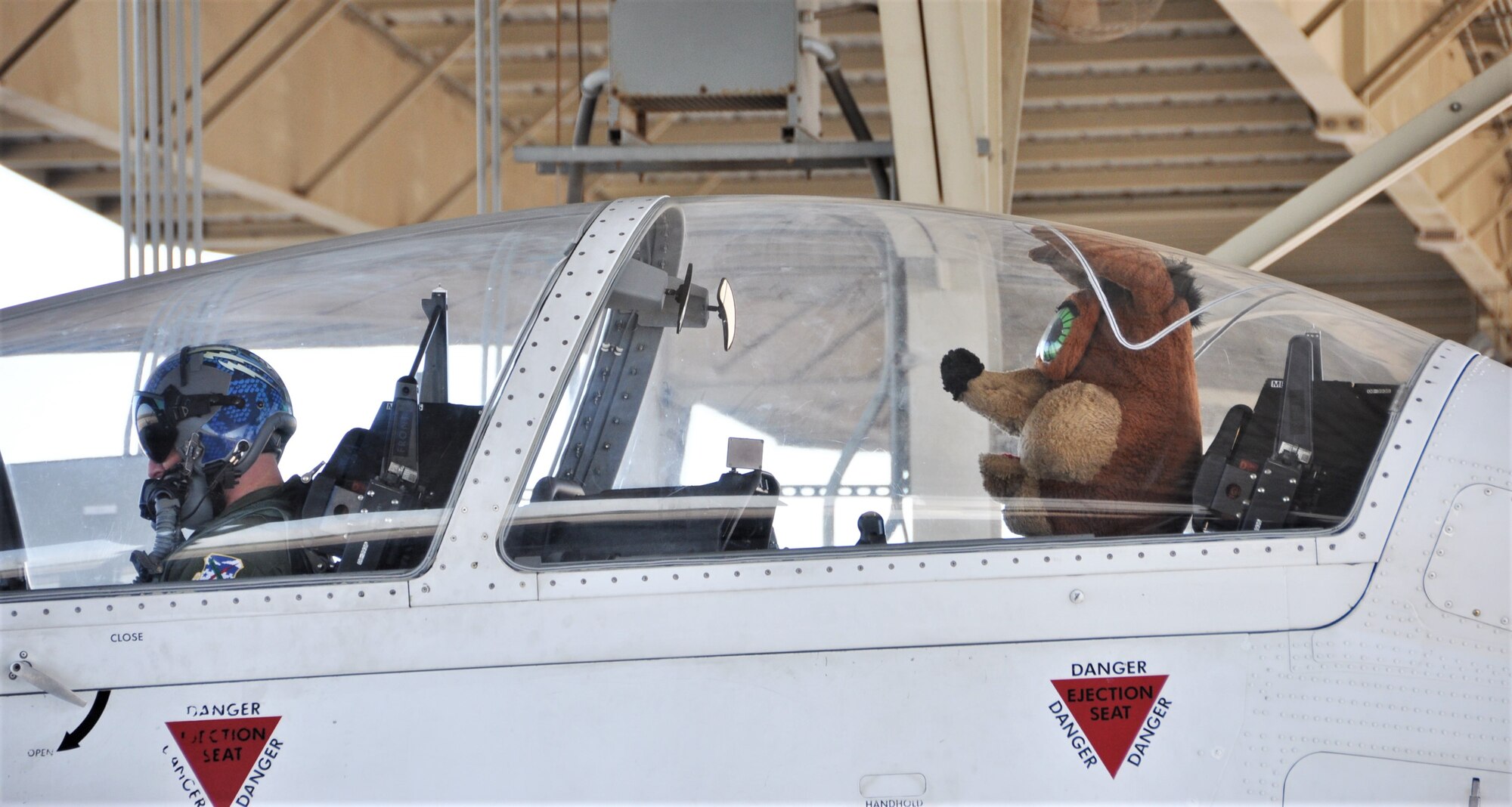 The Spurs Coyote and 340th Flying Training Group instructor pilot– Lt. Col. Mark Pasierb – simulate take off posture at Joint Base San Antonio-Randolph, Texas February 25 where Regular Air Force, Air Force Reserve, and civilian Airmen from the 340th Flying Training Group headquarters, 39th Flying Training Squadron T-6 Texan Flight, 12th Flying Training Wing Safety, 559th Flying Training Squadron T-6 team, and 3rd Combat Camera Squadron (JBSA-Lackland) members, and the NBA San Antonio Spurs production crew worked to put the Coyote through the pilot training process. Video footage will be used for a Spurs Military Appreciation video to be shown during the March 10 game. (U.S. Air Force photo by Janis El Shabazz)
