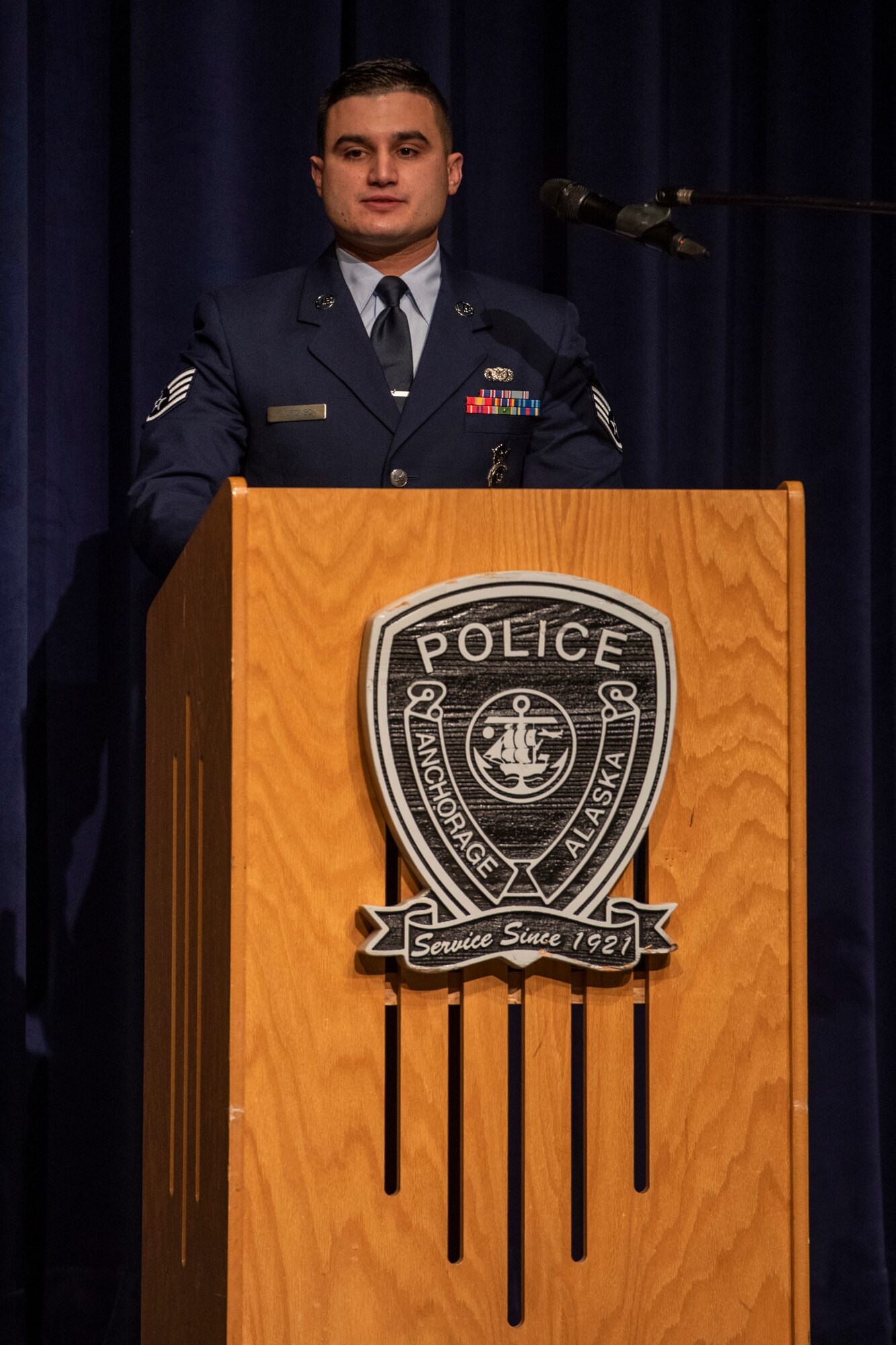 U.S. Air Force Staff Sgt. Ramses Alfonso, 673d Security Forces Squadron lead patrolman, speaks at his Anchorage Police Department 19-1 Academy graduation in Anchorage, Alaska, Dec. 5, 2019. When Alfonso was in fifth grade, he immigrated to the United States from Cuba and learned English. Alfonso earned the Distinguished Honor Graduate Award, Class Valedictorian, Top Shooter, and Top Defensive Driver in the Emergency Vehicle Operations Course. The partnership between the squadron and the Anchorage Police Department provides Airmen with a clearer understanding of municipal police procedures as well as builds contacts with all partner law enforcement agencies who participate in the academy.