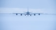 Military refueling taxis on snowy runway.
