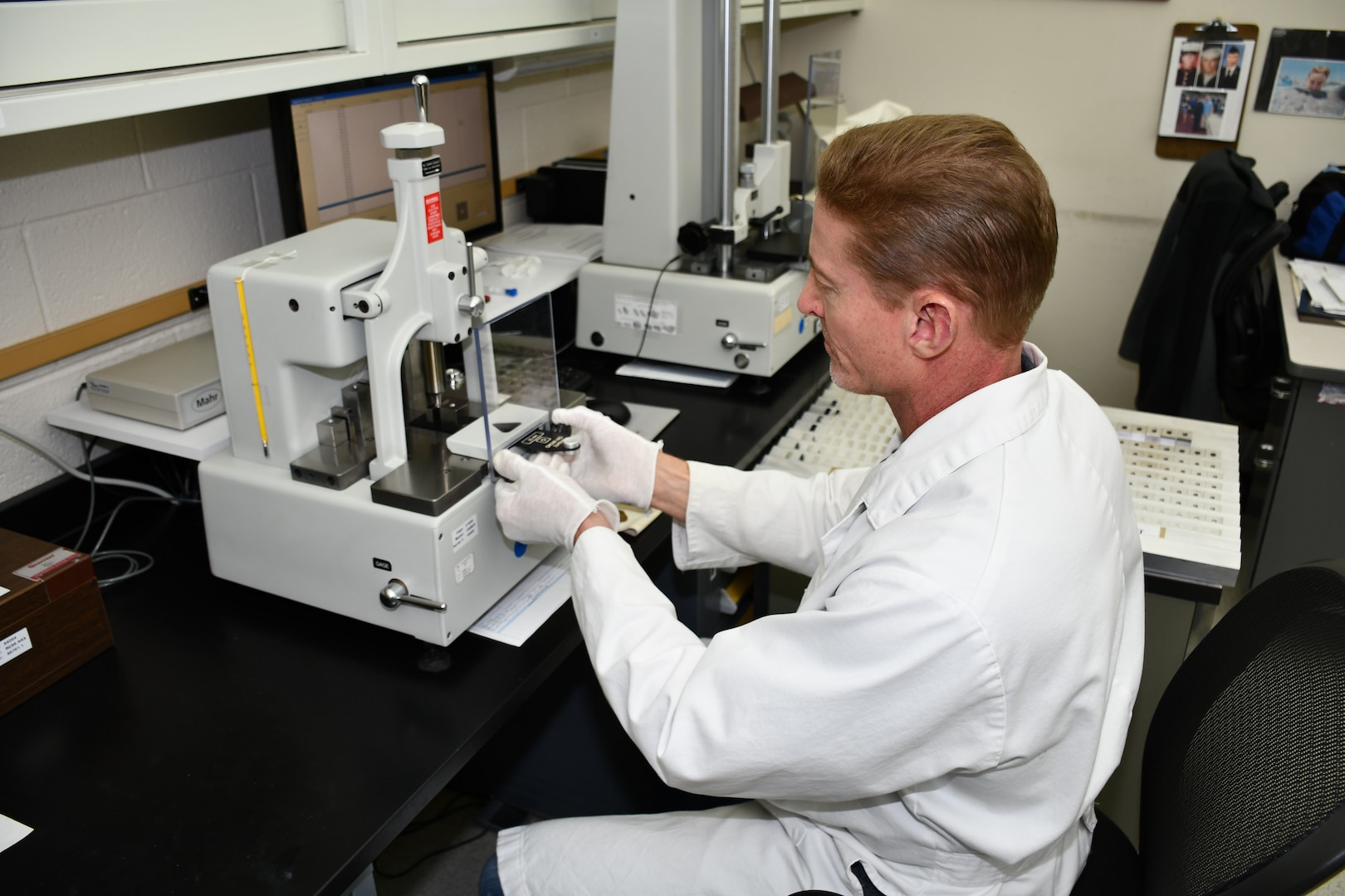 Bill Kubas, Reference Standards Laboratory Technician for the Mid-Atlantic Regional Calibration Center, uses a gage block comparator to perform calibrations for  Submarine Support Facility, New London.