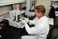 Bill Kubas, Reference Standards Laboratory Technician for the Mid-Atlantic Regional Calibration Center, uses a gage block comparator to perform calibrations for  Submarine Support Facility, New London.