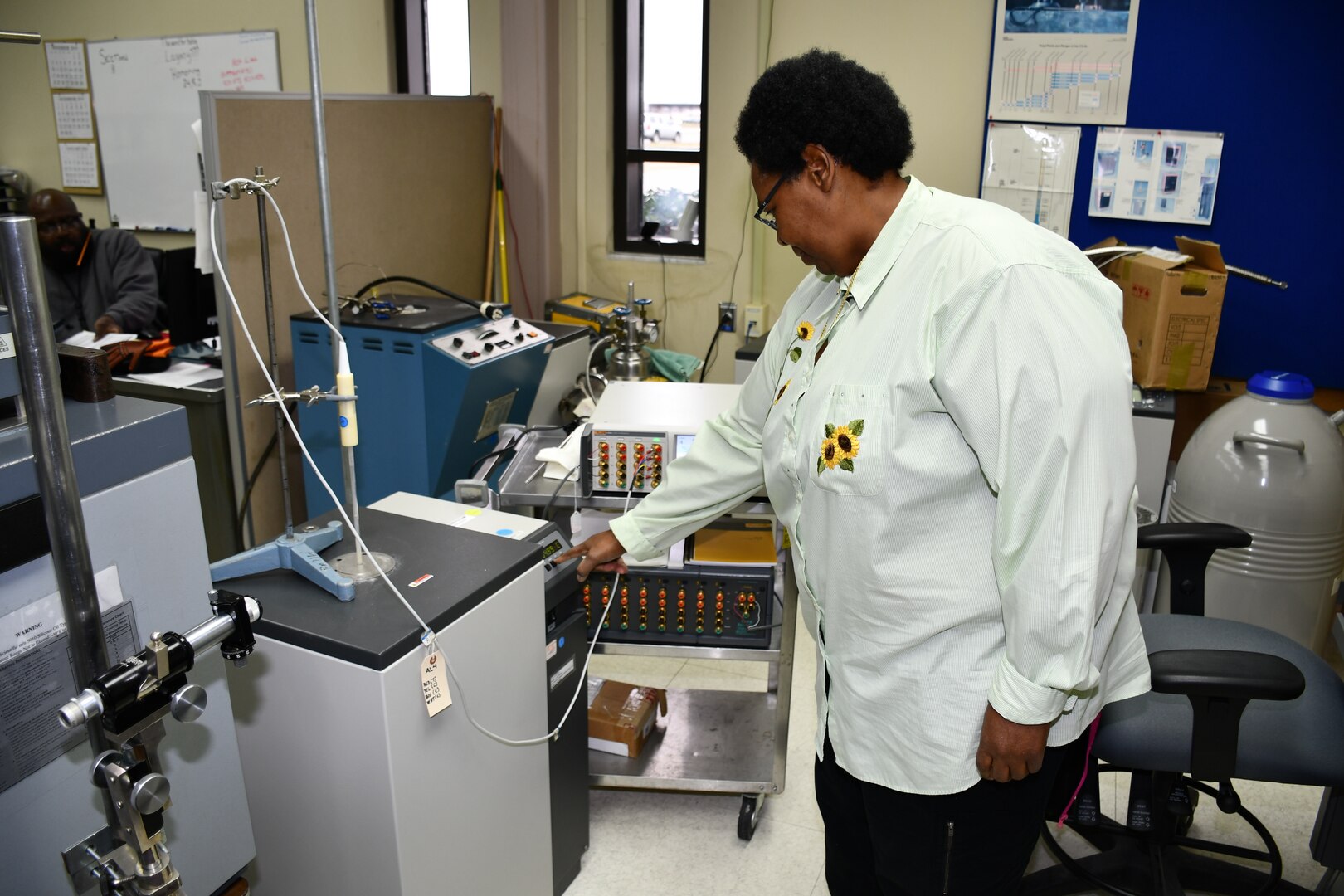 Cheryl Brown, Reference Standards Laboratory Technician for the Mid-Atlantic Regional Calibration Center, adjusts a freeze point furnace while performing a Platinum Resistance Thermometer calibration for Shop 33.
