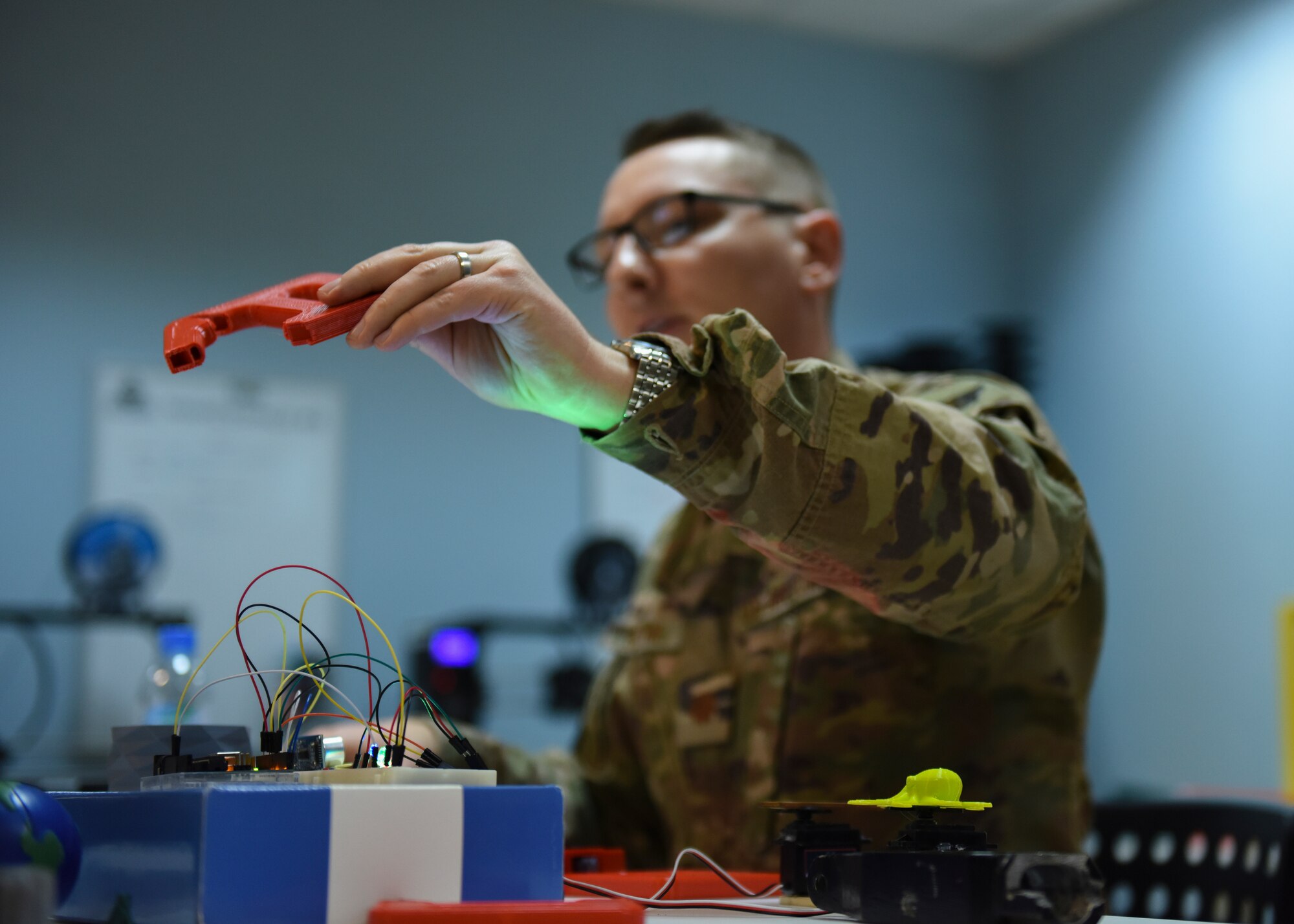 U.S. Air Force Maj. Kyle Boothe, U.S. Air Forces Central Command chief innovation officer, holds a 3D printed item during the AFCENT Innovation Summit in the 379th Air Expeditionary Wing’s Desert Spark Lab at Al Udeid Air Base, Qatar, March 3, 2020.
