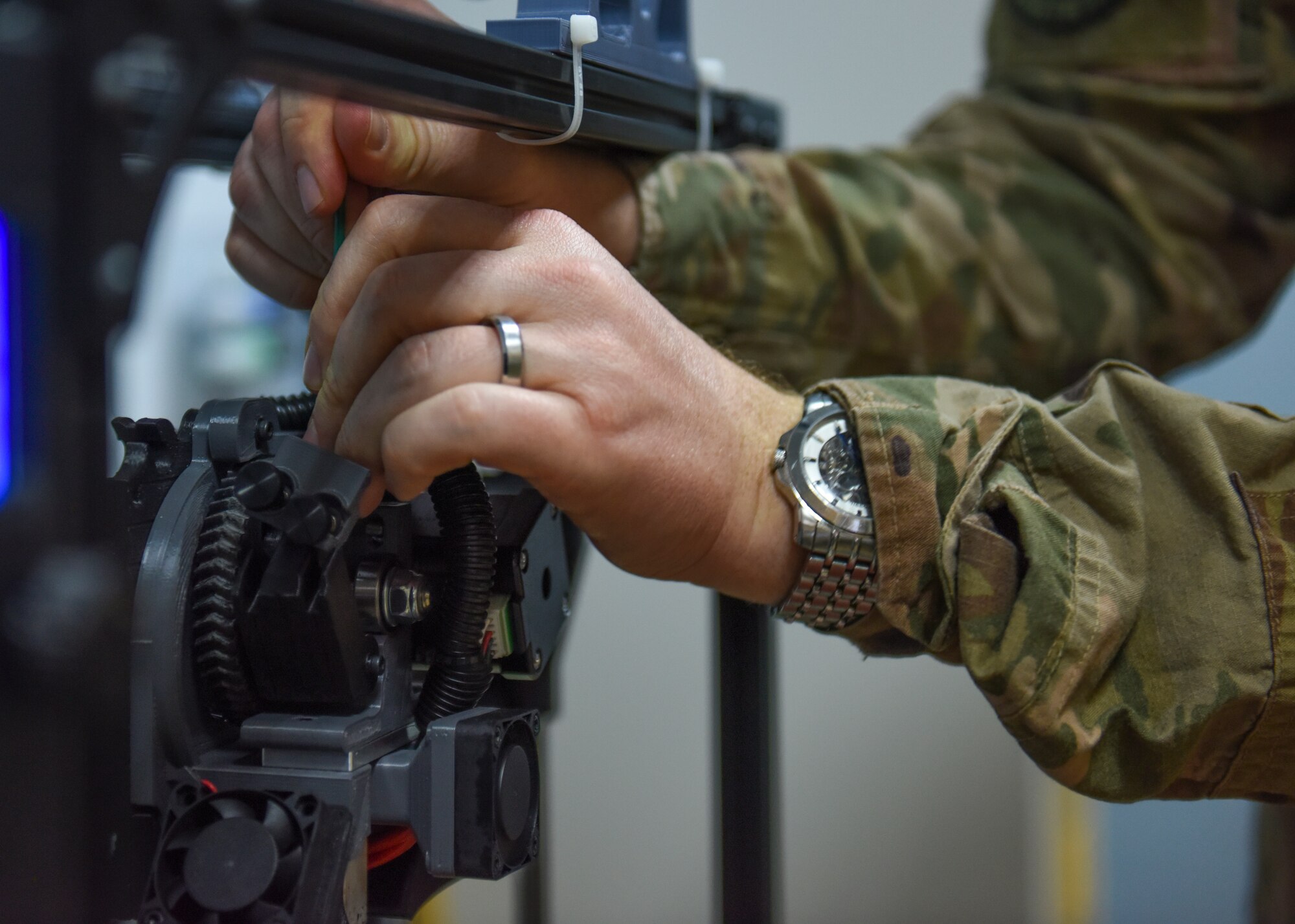 U.S. Air Force Maj. Kyle Boothe, U.S. Air Forces Central Command chief innovation officer, refills the plastic in a 3D printer during the AFCENT Innovation Summit in the 379th Air Expeditionary Wing’s Desert Spark Lab at Al Udeid Air Base, Qatar, March 3, 2020.