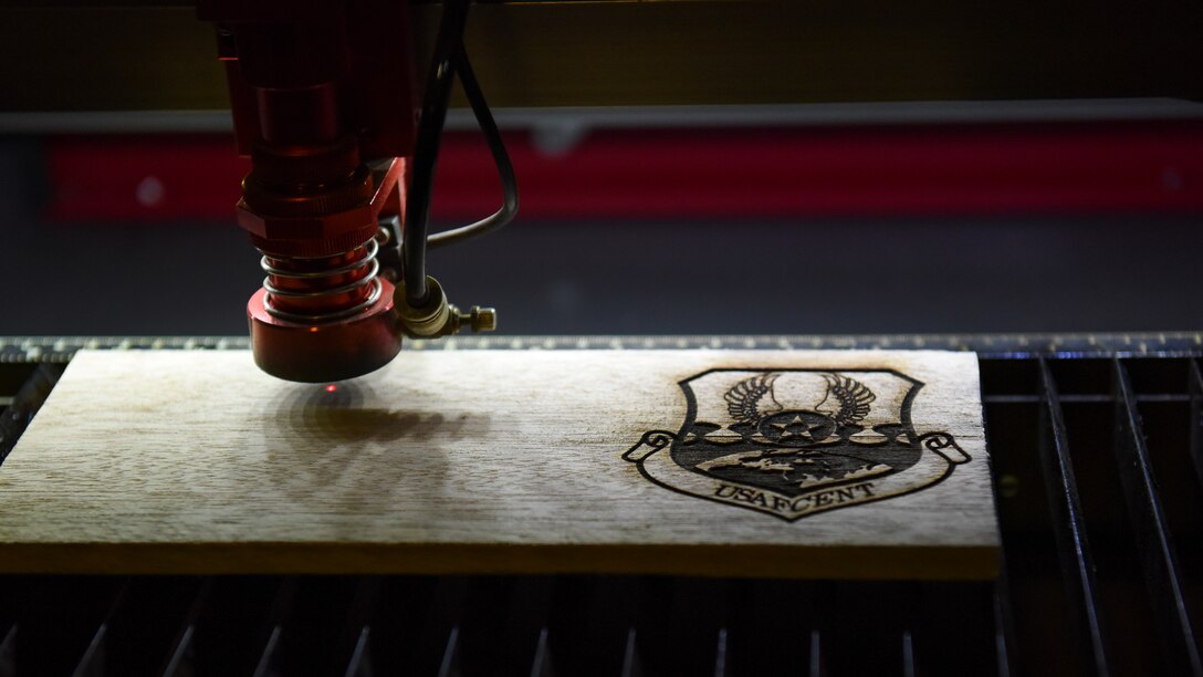A laser cutter etches the U.S. Air Forces Central Command shield onto a piece of wood during the AFCENT Innovation Summit in the 379th Air Expeditionary Wing’s Desert Spark Lab at Al Udeid Air Base, Qatar, March 4, 2020.