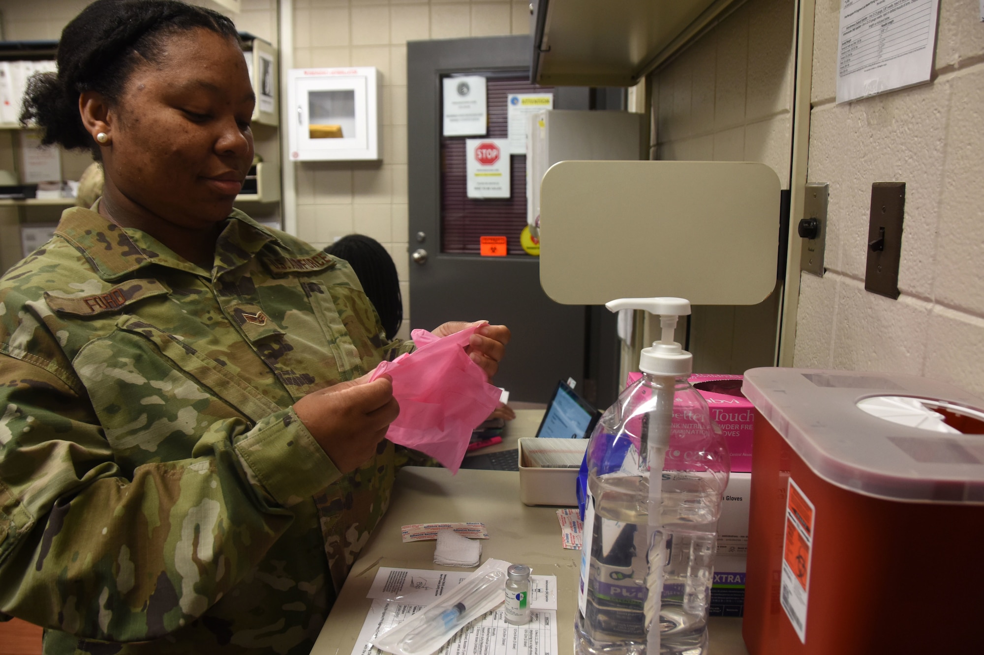 U.S. Air Force Senior Airman Cynthia Ford, 145th Medical Group technician, dons gloves in preparation for giving an immunization at the North Carolina (N.C.) Air National Guard Base, Charlotte Douglas International Airport, Mar. 7, 2020. Senior Airman Ford works as a traditional Guardsman but also serves, in her civilian life, as a Manager for the Department of Juvenile Justice in Marion, S.C. Senior Airman Ford has authored a book titled, ‘Free As An Uncaged Bird,’ which helps acts as a positive and motivational journal, empowering youth and adults. Senior Airman Ford was recently nominated by WBTW News 13 in her local area as Woman of the Year for one of their segments; she has won for her area and will fly to New York mid-March to compete for Woman of the Year Nationally.