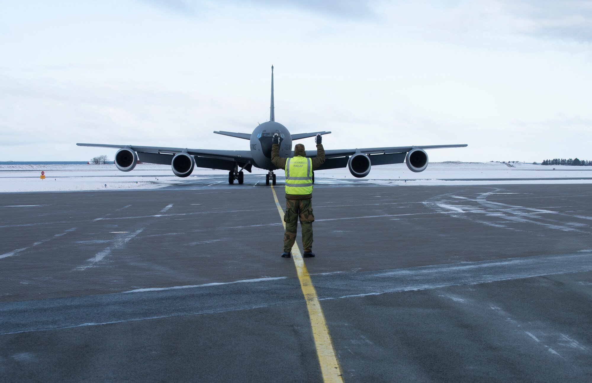 Airmen taxiing military refueling aircraft.
