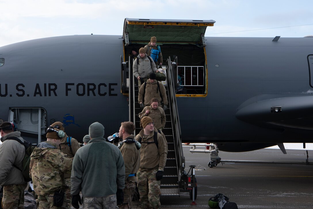 Airmen offloading a military refueling plane.