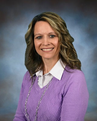 official photo lady in purple shirt against a blue background