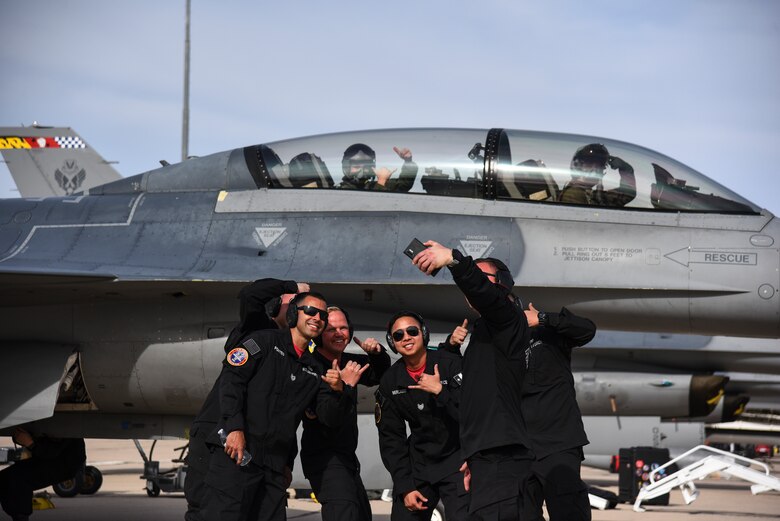A photo of Airmen taking a selfie in front of an F-16 before takeoff.