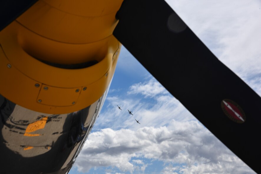 A photo of a P-47 and two P-51s flying together in formation.