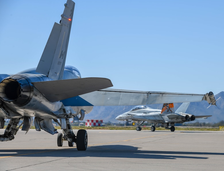 Two Royal Canadian air force CF-18 Hornets, assigned to the 433rd Tactical Fighter Squadron in Canadian Forces Base Bagotville, Quebec, Canada, taxi into position for takeoff Feb. 25, 2020, at Luke Air Force Base, Ariz.