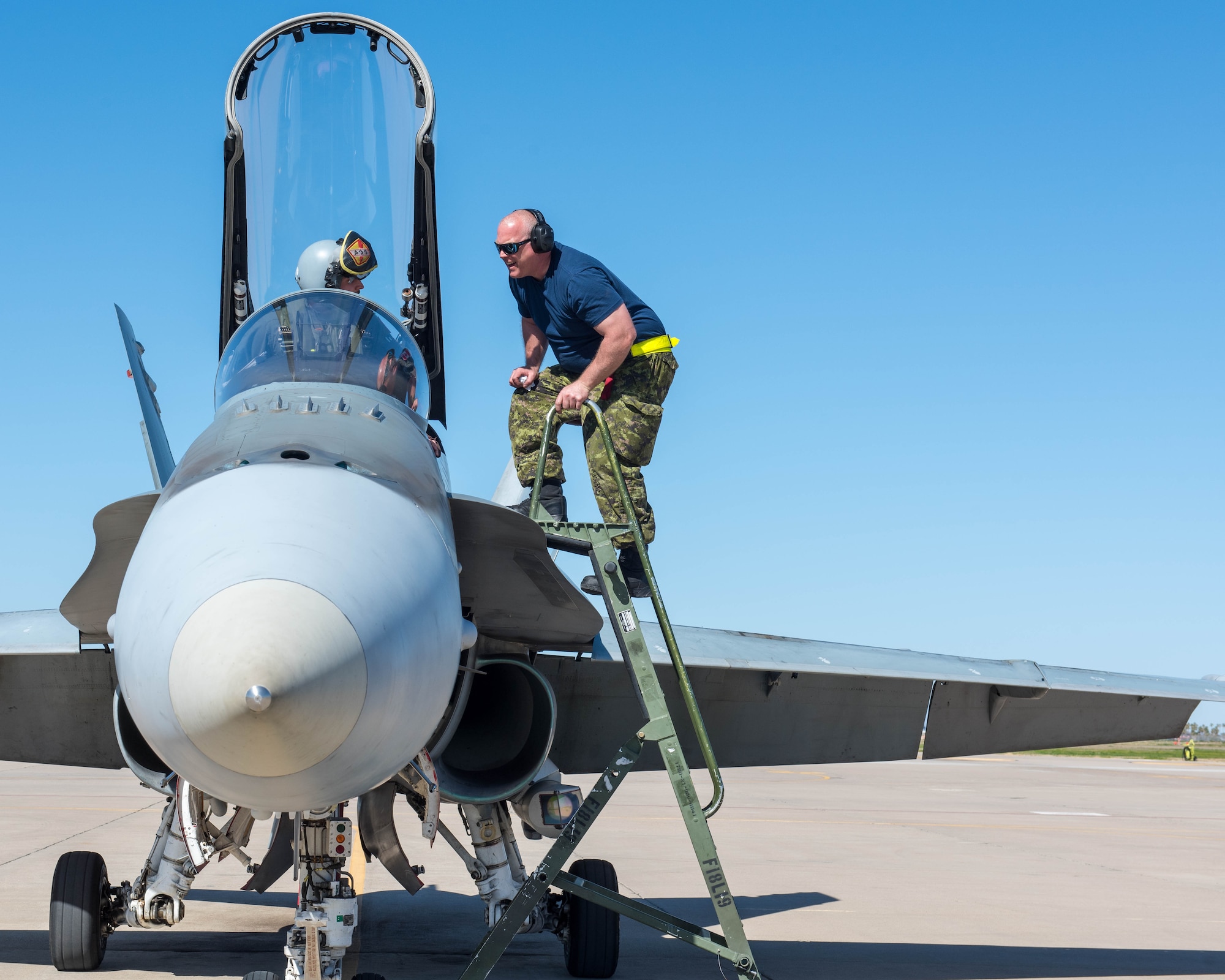 A Royal Canadian air force CF-18 Hornet pilot and crew chief, assigned to the 433rd Tactical Fighter Squadron in Canadian Forces Base Bagotville, Quebec, Canada, prepare for takeoff Feb. 25, 2020, at Luke Air Force Base, Ariz.