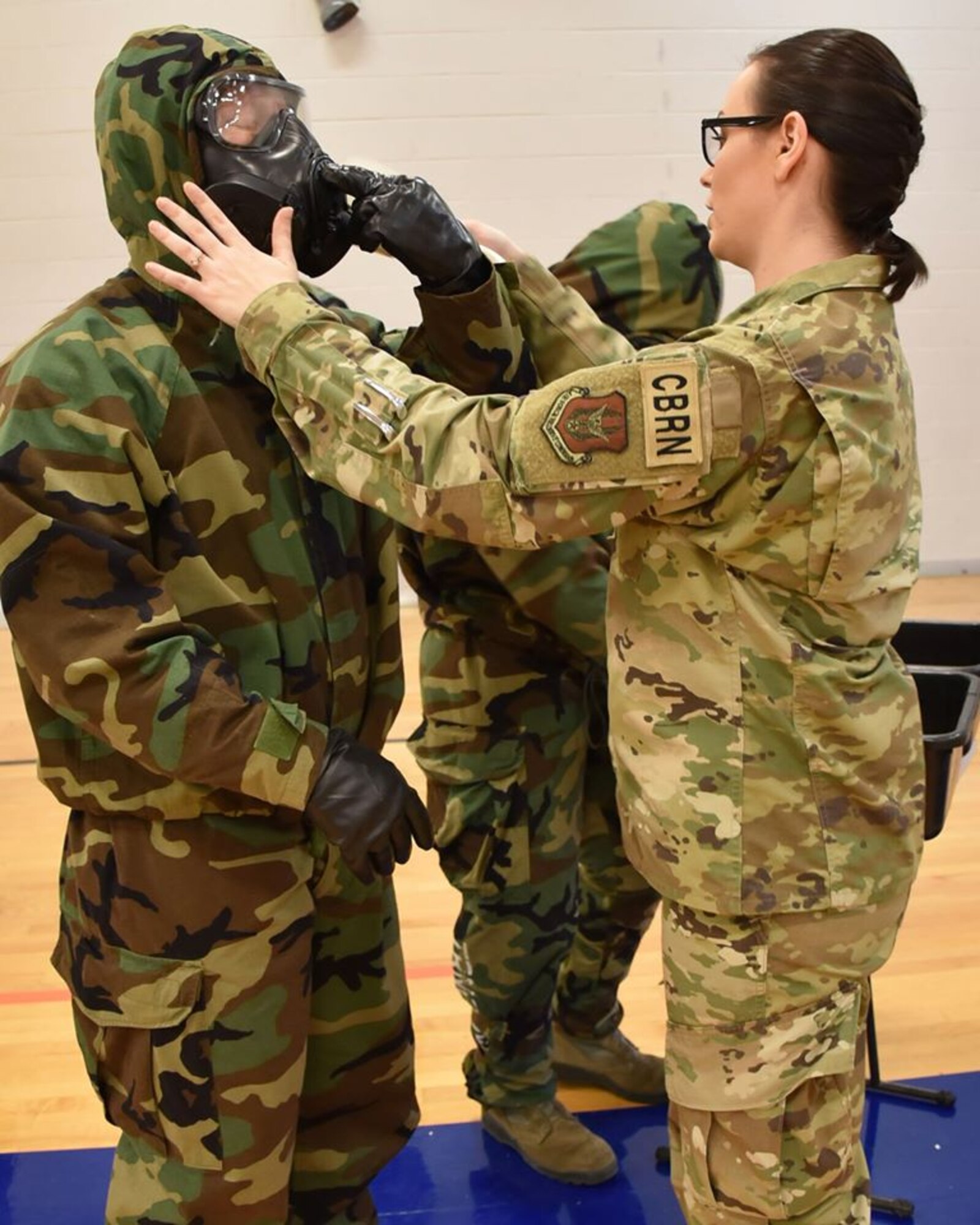 Tech. Sgt. Ellie Drake, 931st Civil Engineer Readiness Chemical, Biological, Radiological and Nuclear Defense non-commissioned officer, helps an Airman assigned to the 931st Air Refueling Wing with his gas mask during an annual readiness assessment March 8, 2020 at McConnell Air Force Base, Kan.  The Assessment provides Airmen with the training they need in order to carry out mission requirements with efficiency and accuracy.