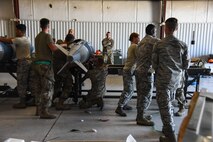 A photo of Airmen working on a bomb.