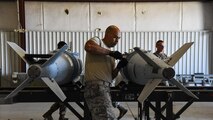 A photo of an Airman working on a bomb.