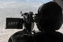 A photo of a Marine sitting behind the gun of an MV-22B Osprey