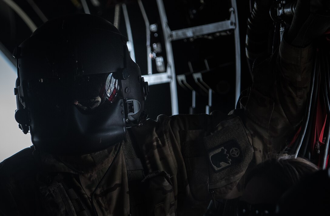 U.S. Army Staff Sgt. Job Smith, 159th General Support Aviation Brigade 244th Bravo Company standardization instructor non-rated crewmember, grips a handle inside a CH-47 Chinook helicopter on the way to a Field Training Exercise at Wilcox, Virginia, March 6, 2020. Smith performed in-flight checks periodically during the flight. (U.S. Air Force photo by Airman 1st Class Sarah Dowe)