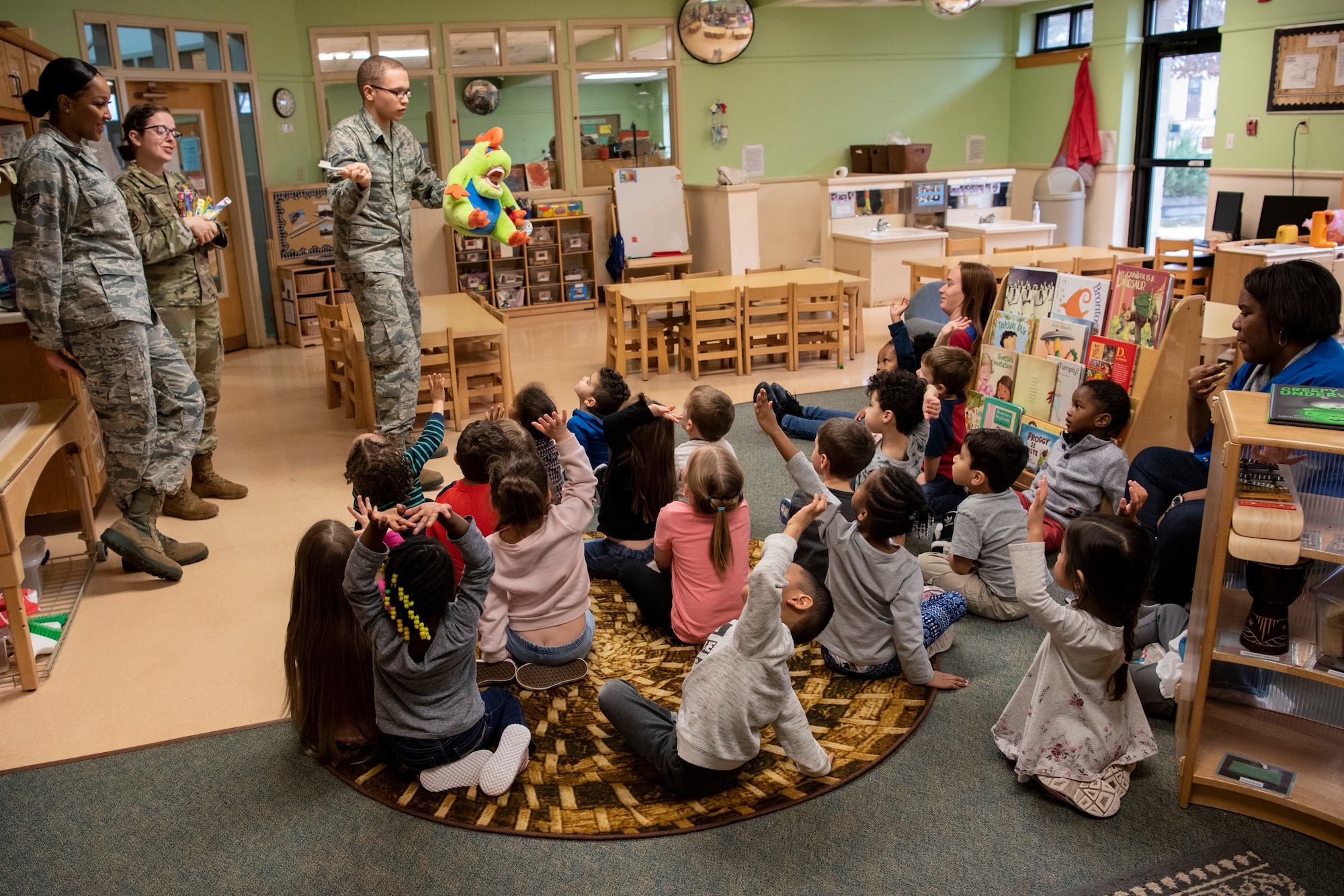 Airmen teach kids the proper way to brush their teeth using a toy dinosaur.