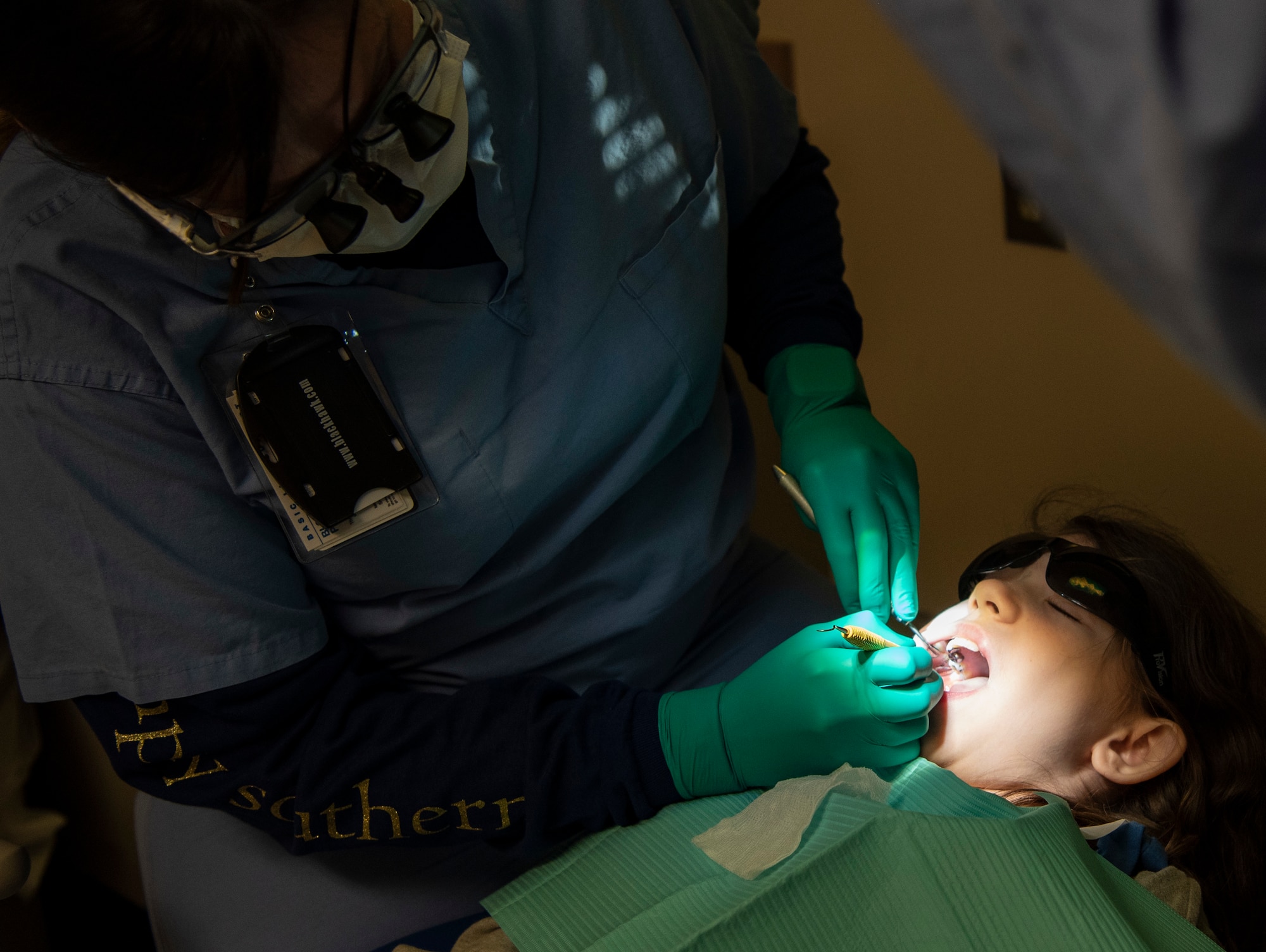 A Shaw dentist cleans the teeth of a child.