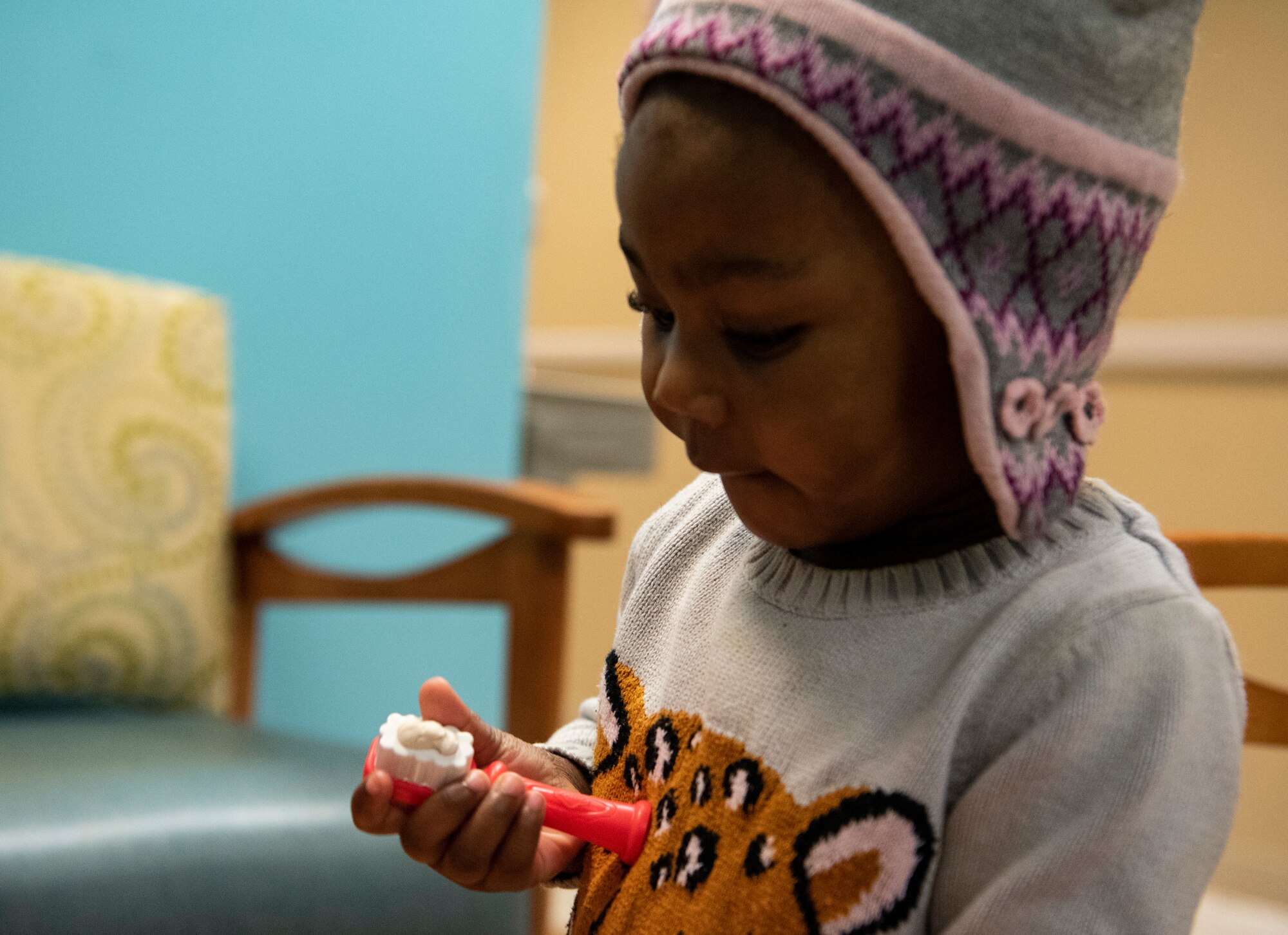 Child plays with toy toothbrush.