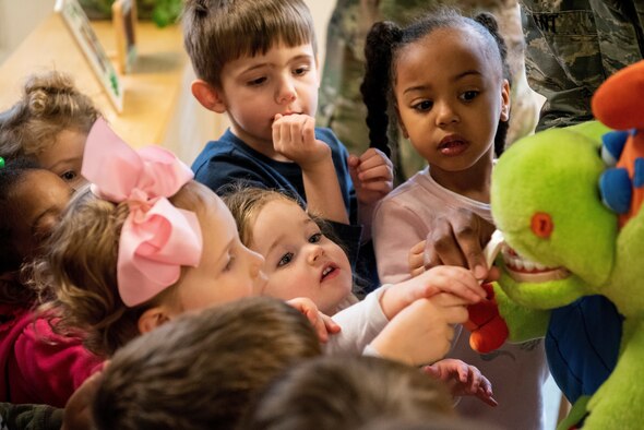 Kids brush toy dinosaur's teeth.