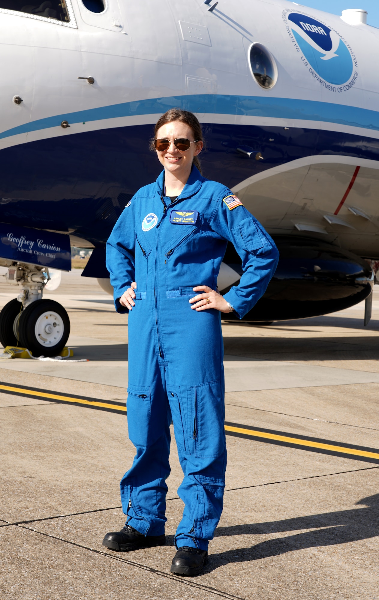 Ashley Lundry, a flight director for the National Oceanic and Atmospheric Administration Hurricane Hunters in Lakeland Fla., stands in front of a Lockheed WP-3D Orion at Keesler Air Force Base, Miss., Nov. 13, 2019. Lundry is also an aerial reconnaissance weather officer for the Air Force Reserve's 53rd Weather Reconnaissance Squadron "Hurricane Hunters." (U.S. Air Force photo by Senior Airman Kristen Pittman)