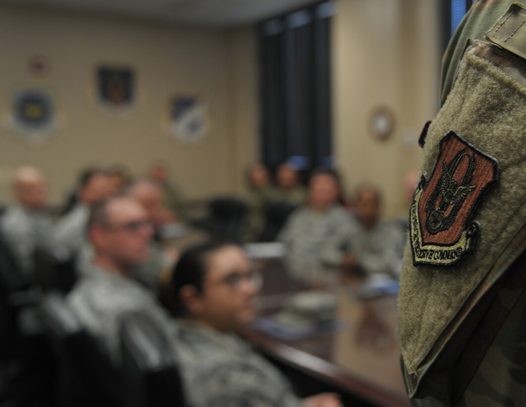 a person stands in front of others in a conference room.