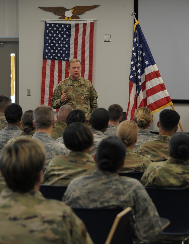 a person stands in front of others in a conference room.