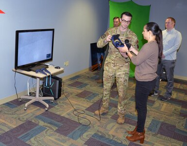Staff Sgt. Tyler Williams, Career Enlisted Aviator Center of Excellence basic boom operator instructor, assists Laura Cabanilla, San Antonio Chamber/San Antonio Hispanic Chamber of Commerce co-chair Leadership San Antonio 44, don a virtual reality headset during an honorary commander tour of the 433rd Operations Group March 7, 2020 at Joint Base San Antonio-Lackland, Texas.