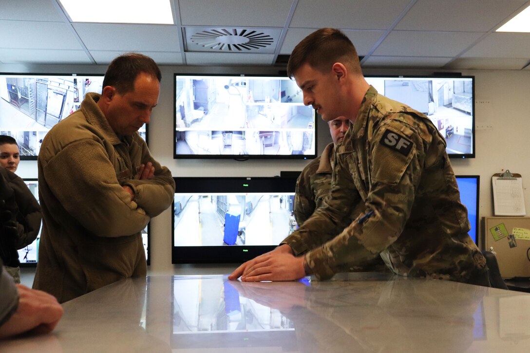 Photo of Major General Shaw receiving a briefing from an airman
