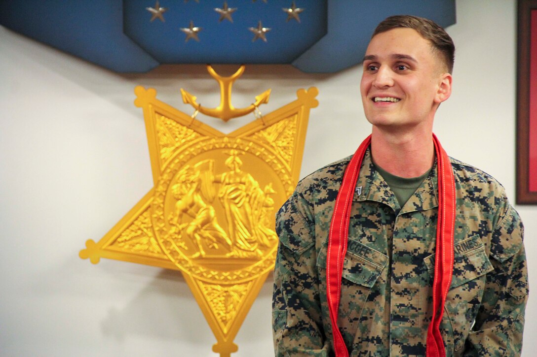 Cpl. McGee smiles with his blood stripes around his neck after his promotion.