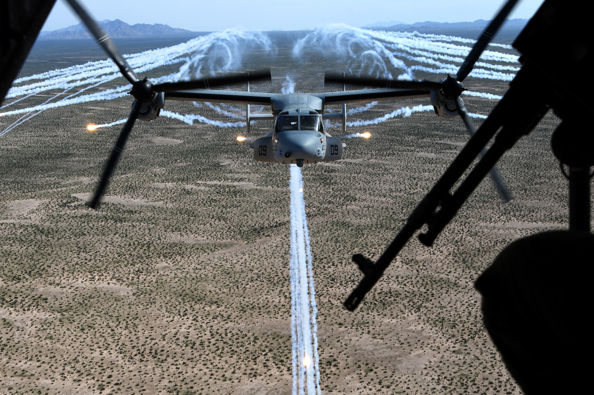 A photo of an MV-22B Osprey firing flares