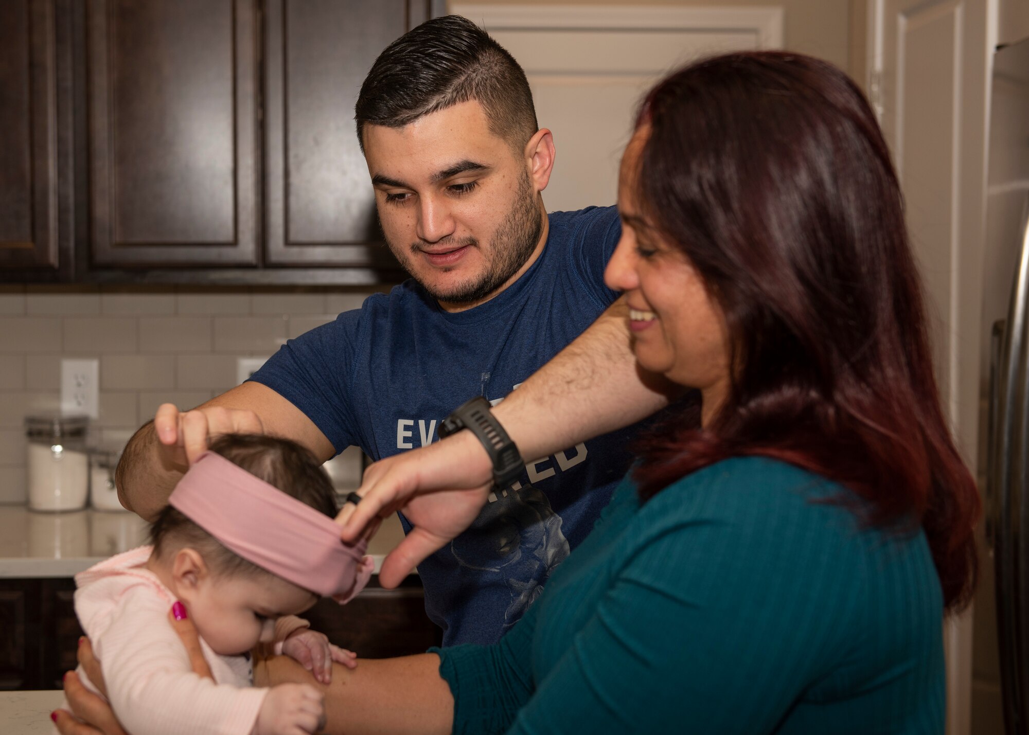 U.S. Air Force Staff Sgt. Ramses Alfonso, 673d Security Forces Squadron lead patrolman, adjusts his daughter’s headband while his mother holds his daughter in Anchorage, Alaska, Dec. 20, 2019. When Alfonso was in fifth grade, he immigrated to the United States from Cuba and learned English. Alfonso graduated from Anchorage Police Department 19-1 Academy and earned the Distinguished Honor Graduate Award, Class Valedictorian, Top Shooter, and Top Defensive Driver in the Emergency Vehicle Operations Course.