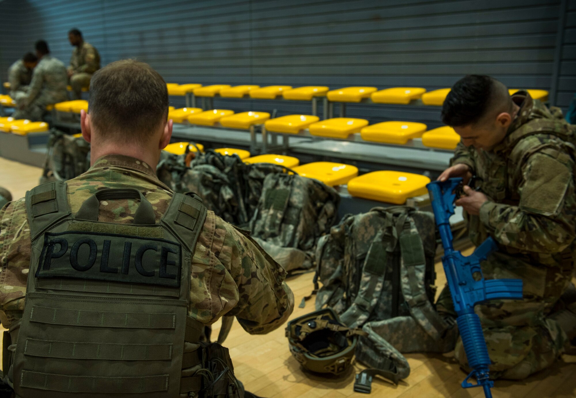 Two U.S. Air Force security forces members don their "battle rattle" in preparation to conduct a ruck march.