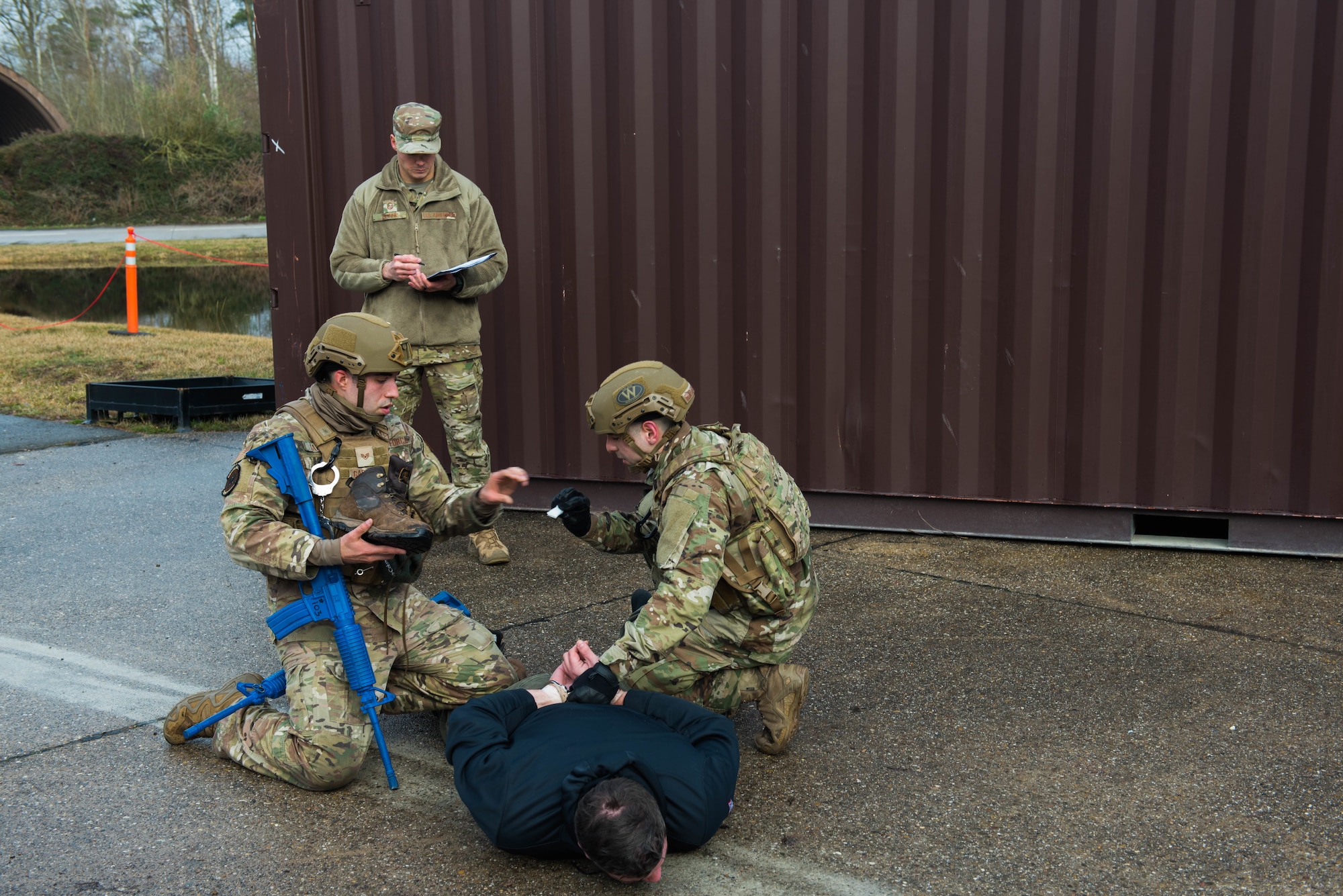Two U.S. Air Force security forces members conduct a body search for a training evaluation.
