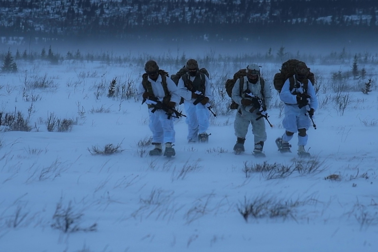 Paratroopers cross a snowy field.