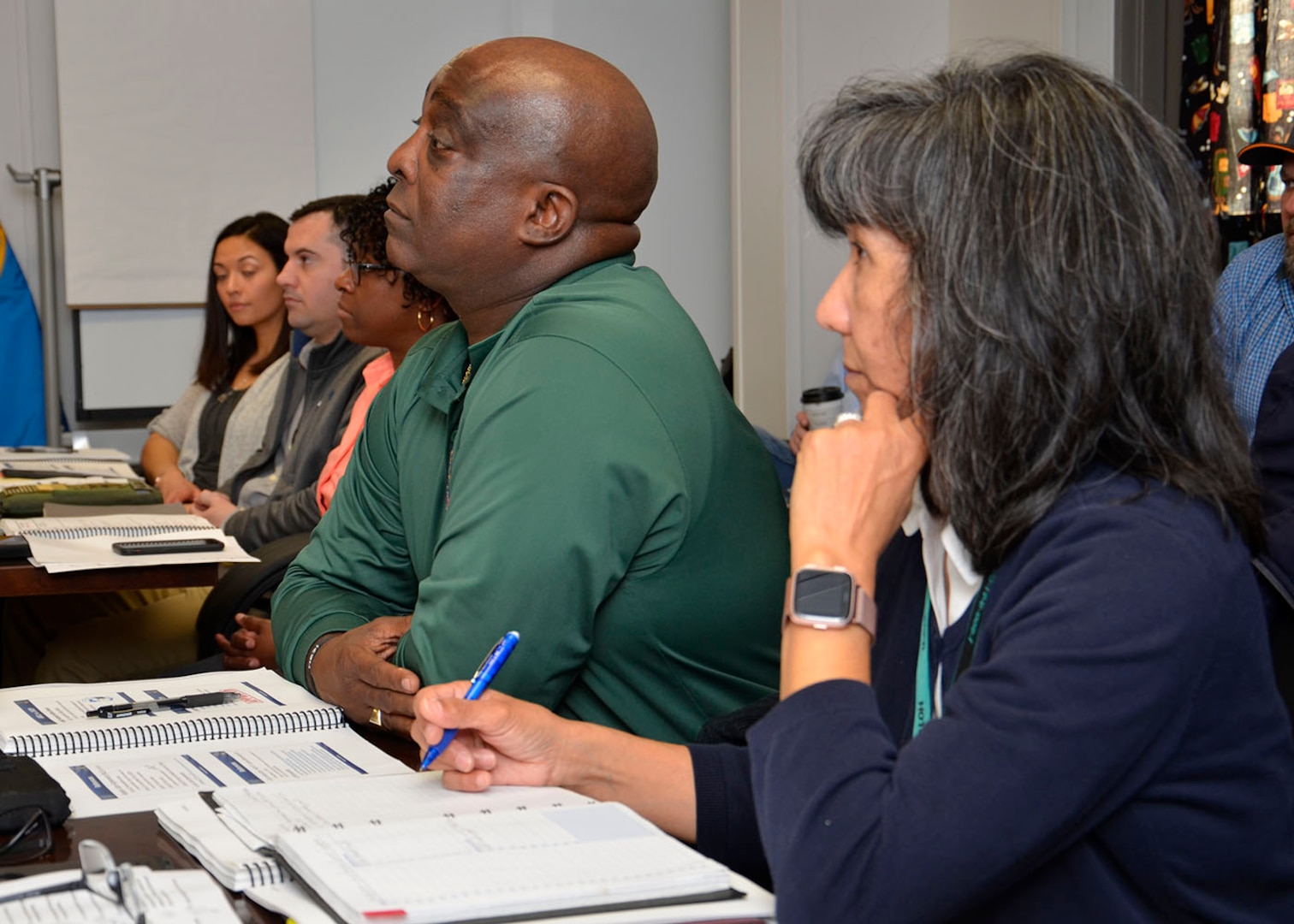 Two people set at a desk and listen to leadership summit