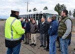 Members of a tour listen to a tour guide outside