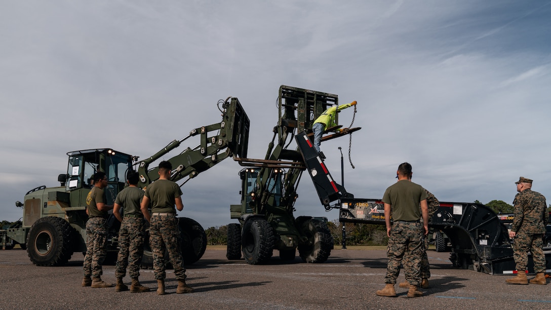 Troops mill around heavy equipment.