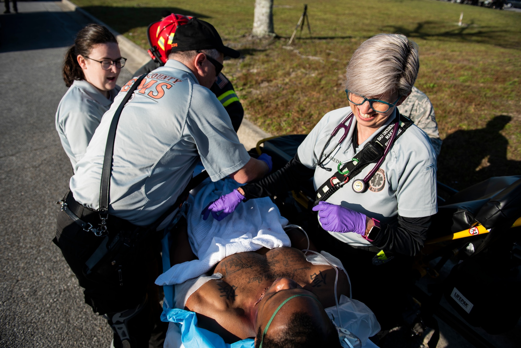 Ashley Thompson, left, Pete Russ, center, and Kelly Guillory, Bay County Emergency Medical Services technicians, load a simulated medical emergency patient during an emergency medical joint exercise at Tyndall Air Force Base, Florida, March 12, 2020. Bay County EMS responded to the scene and facilitated patient transfer to the local hospital. This was a critical point of the exercise training to practice patient hand offs successfully. (U.S. Air Force photo by Staff Sgt. Magen M. Reeves)