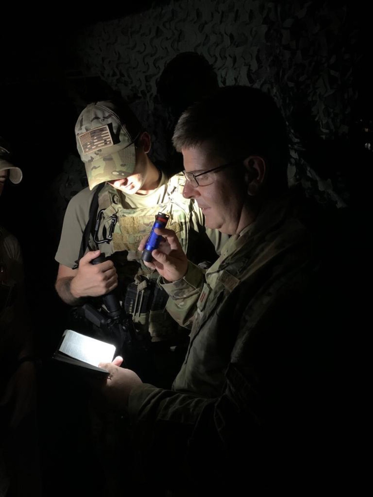 Chaplain (Maj.) John Russell from the 117th Air Refueling Wing, Sumpter Smith Joint National Guard Base, Birmingham, AL pauses with military personnel to read scripture during a recent deployment. (U.S. Air National Guard photo)