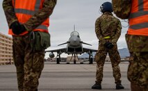 Airman stand on the flight line.
