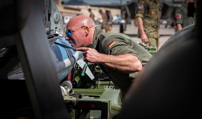 Airman tightens screw on a jet.